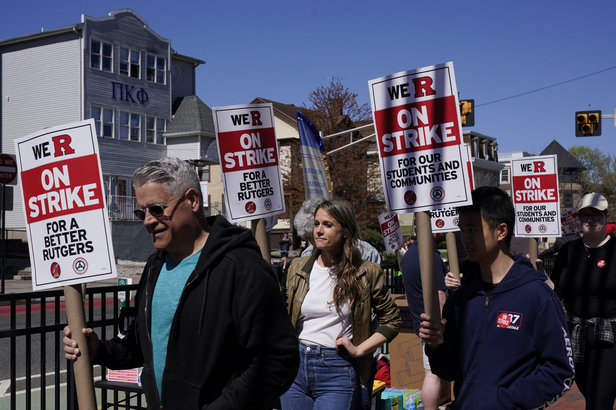 Strikers march in front of Rutgers' buildings in New Brunswick, N.J., Monday, April 10, 2023. Thous...