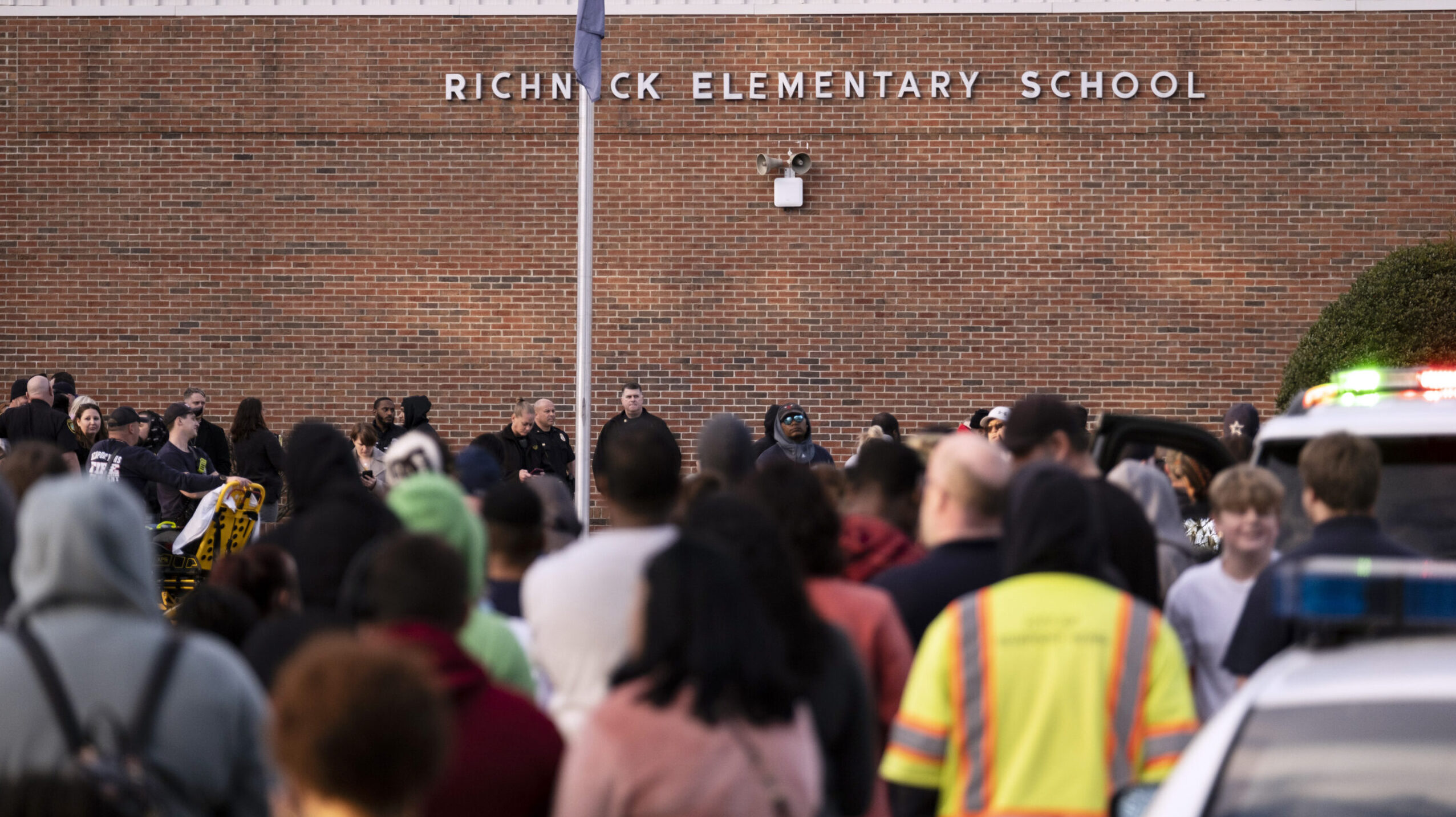 FILE - Students and police gather outside of Richneck Elementary School after a shooting, Jan. 6, 2...
