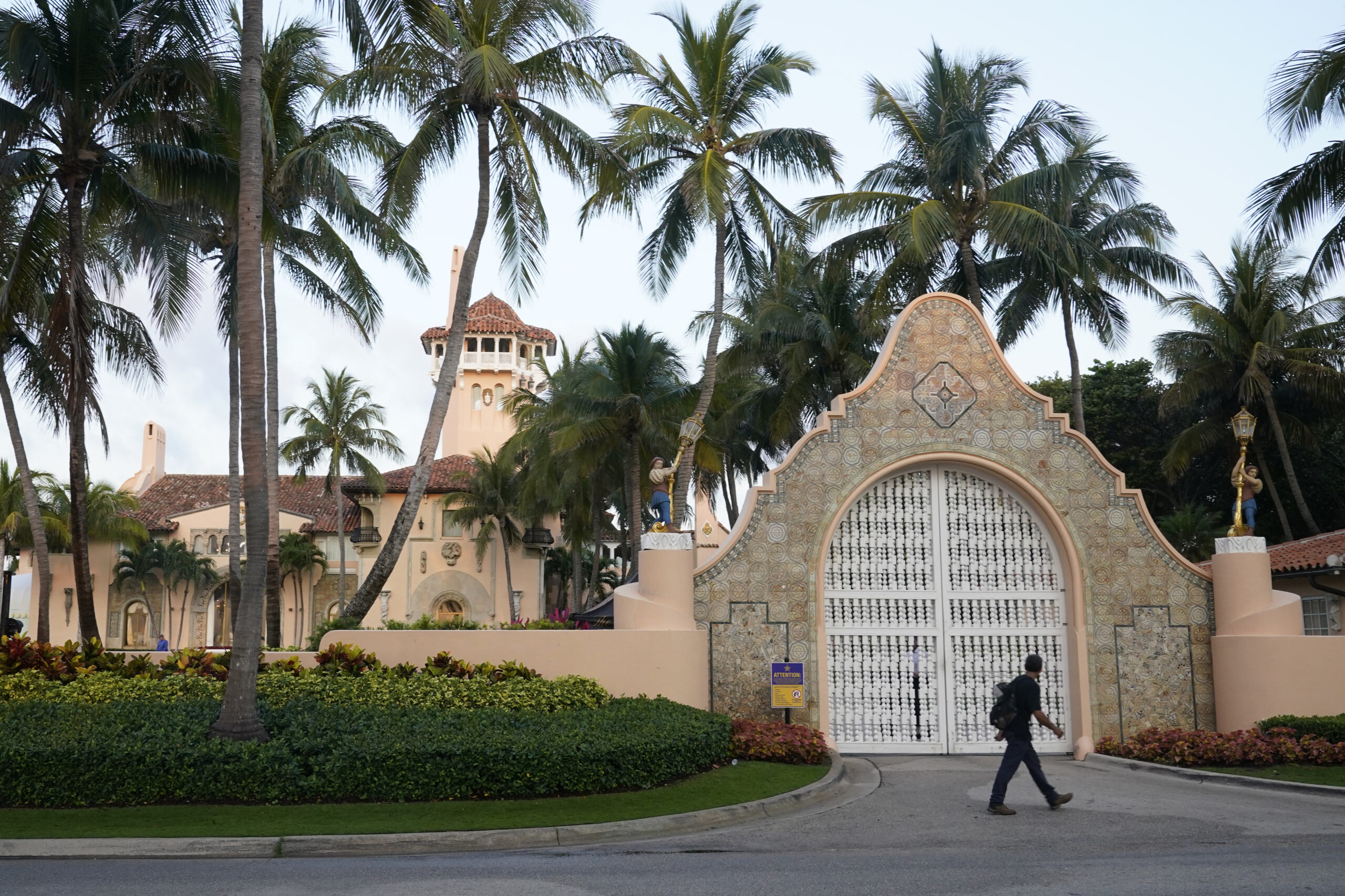 A pedestrian walks by the entrance of the Mar-a-Lago club, Monday, April 3, 2023, in Palm Beach, Fl...