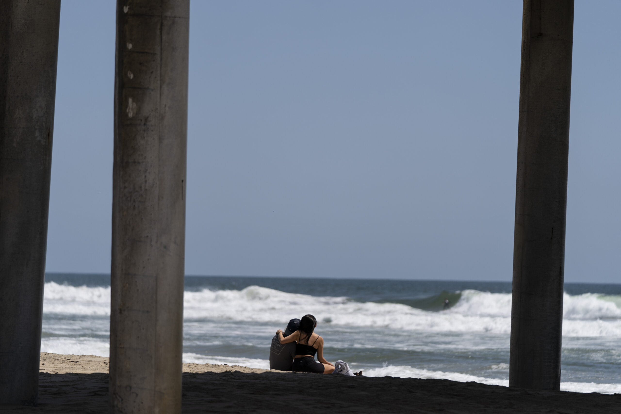 A young couple sit on the beach in Huntington Beach, Calif., Monday, May 8, 2023. For years, studie...