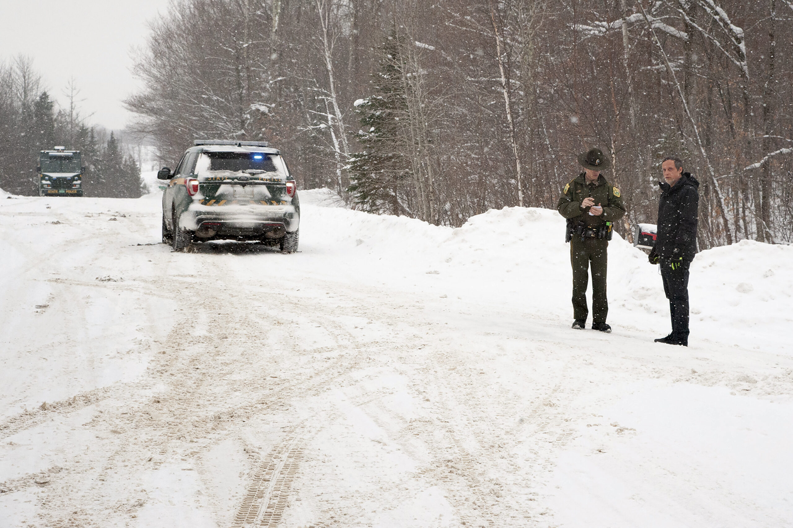 FILE - A Vermont state trooper, center, speaks to a homeowner, Jan. 8, 2018, near an area on Peacha...