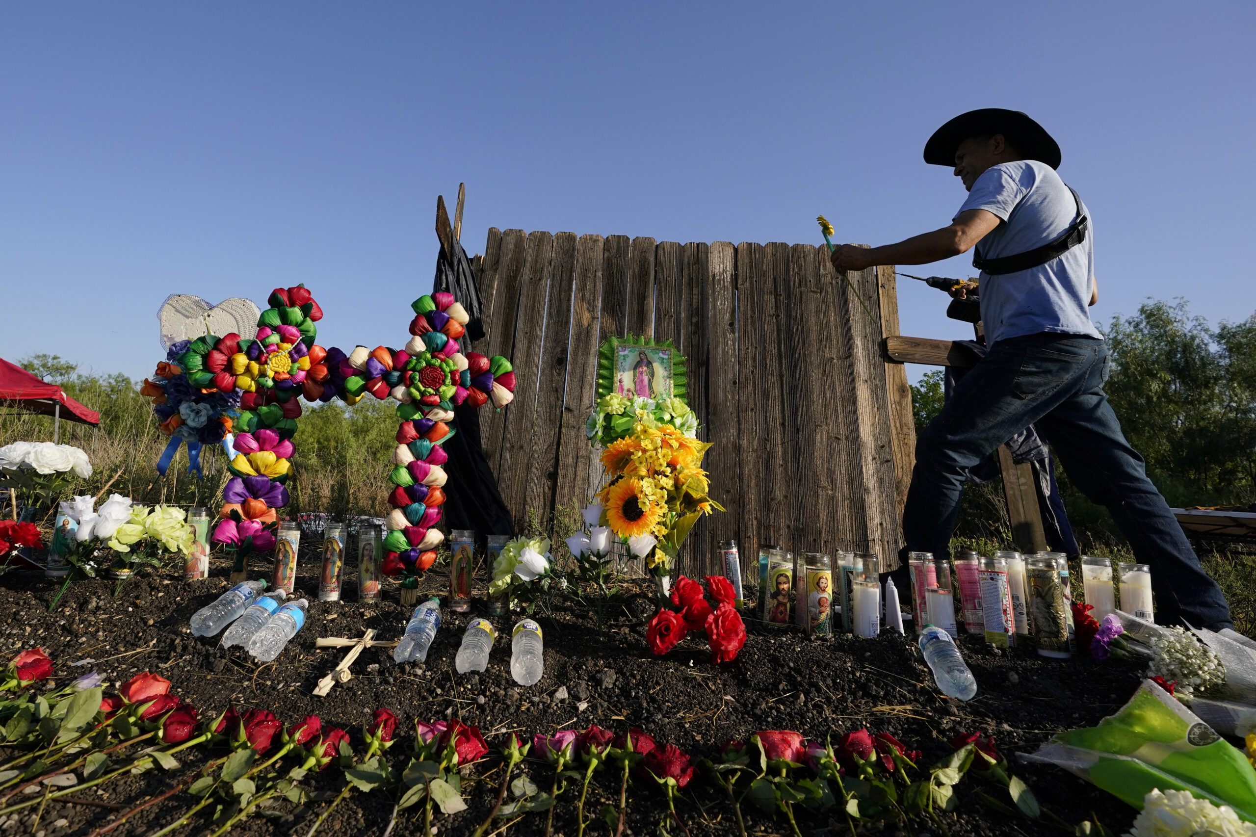 FILE - Roberto Marquez, of Dallas, adds a flower a makeshift memorial at the site where officials f...