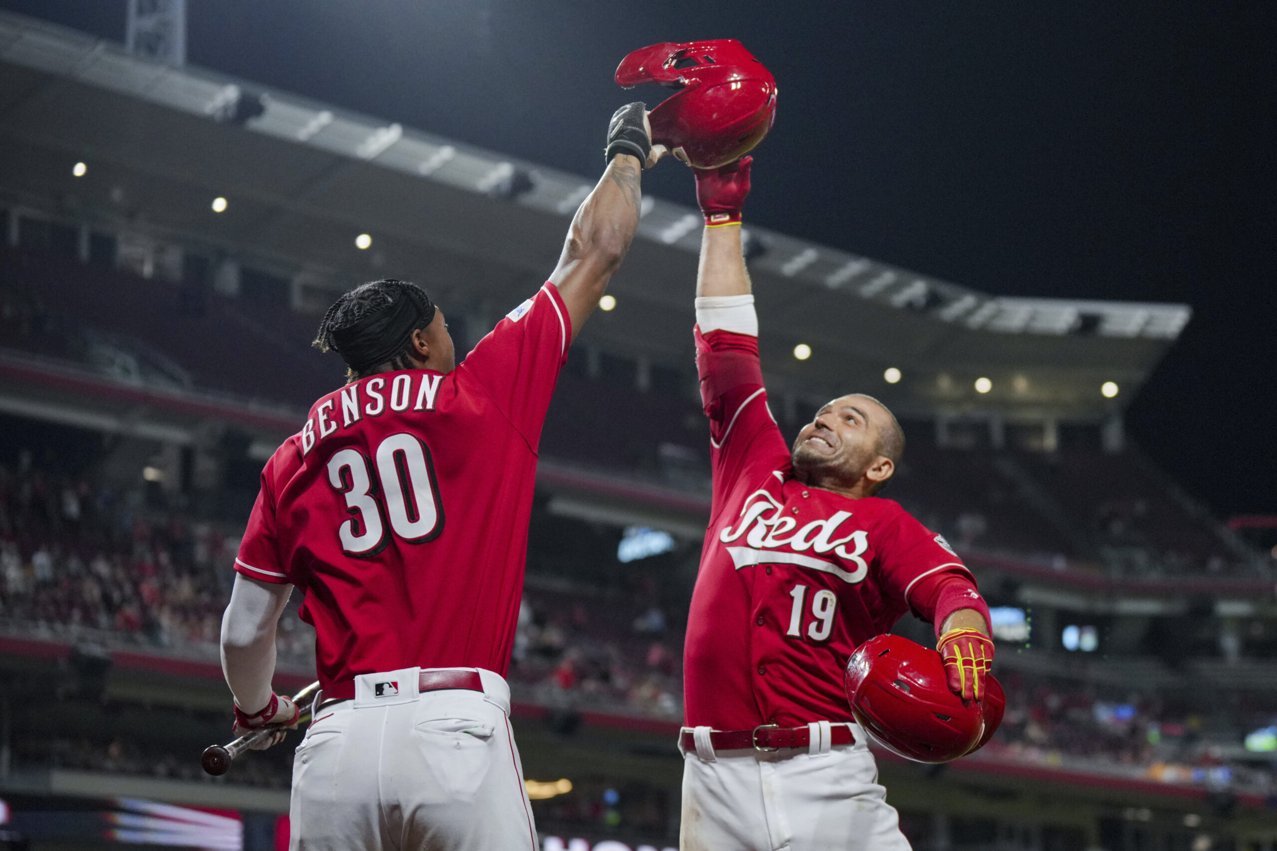 Cincinnati Reds' Joey Votto, right, celebrates with Will Benson after hitting a two-run home run ag...