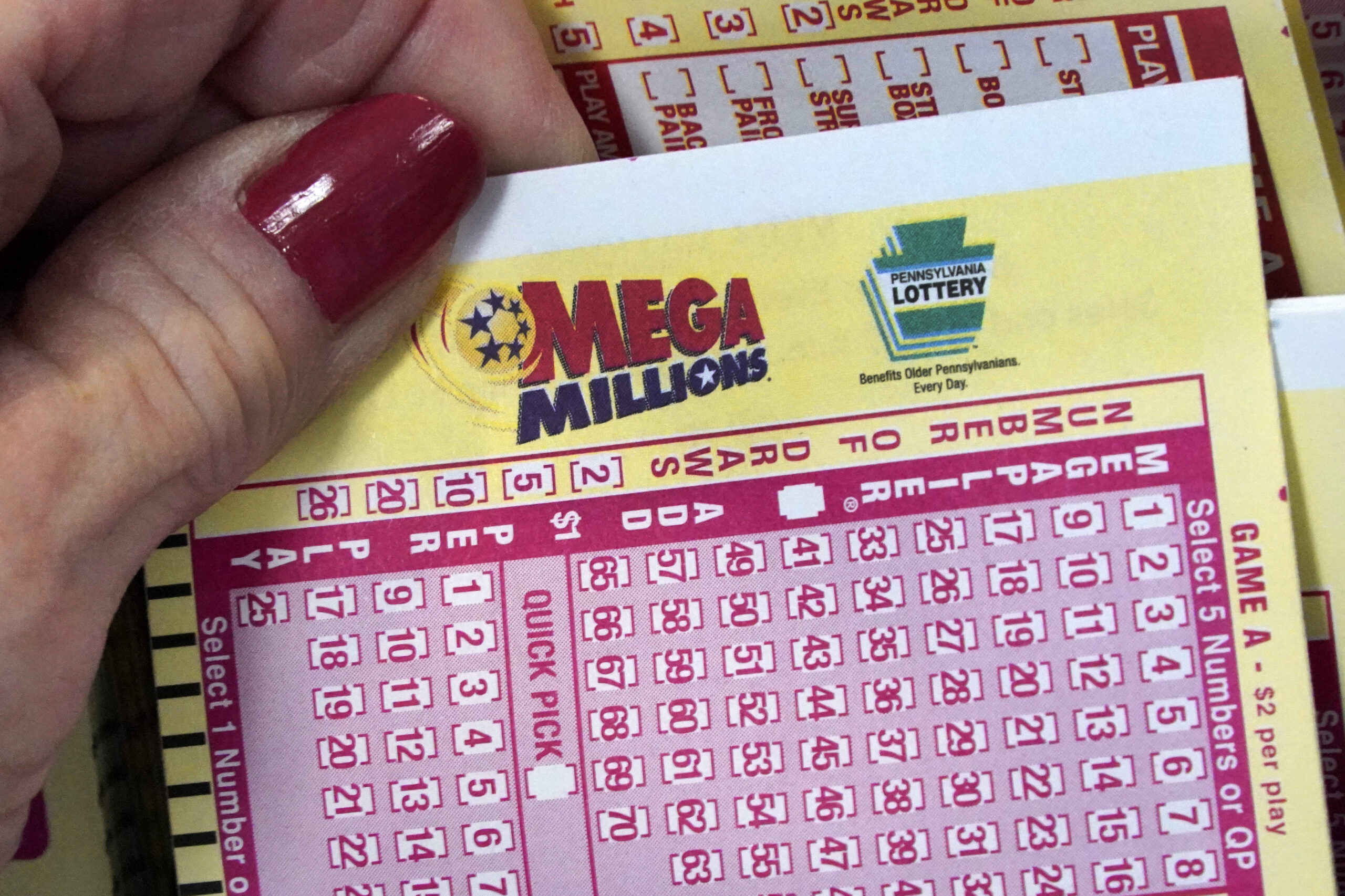 FILE - A Mega Millions wagering slip is held in Cranberry Township, Pa., Jan. 12, 2023. The huge $8...