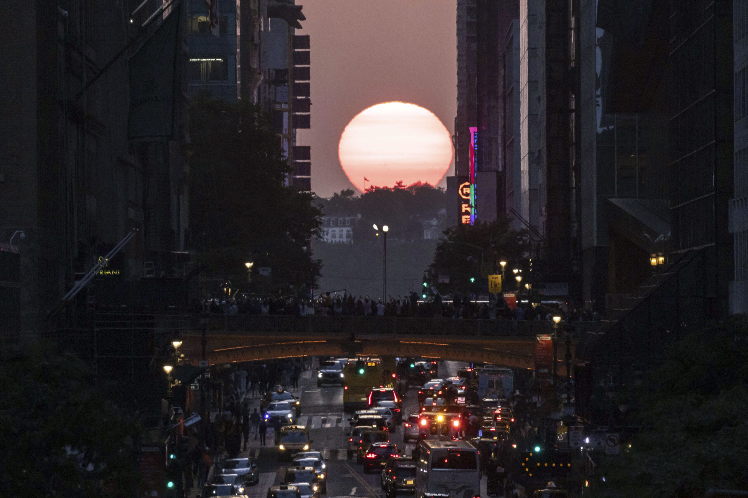 FILE — The sun sets between buildings along 42nd Street in New York during a phenomenon known as ...
