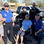 Officers pose with the two seniors who had been living in an apartment without an air conditioning unit. (Surprise Police Department)