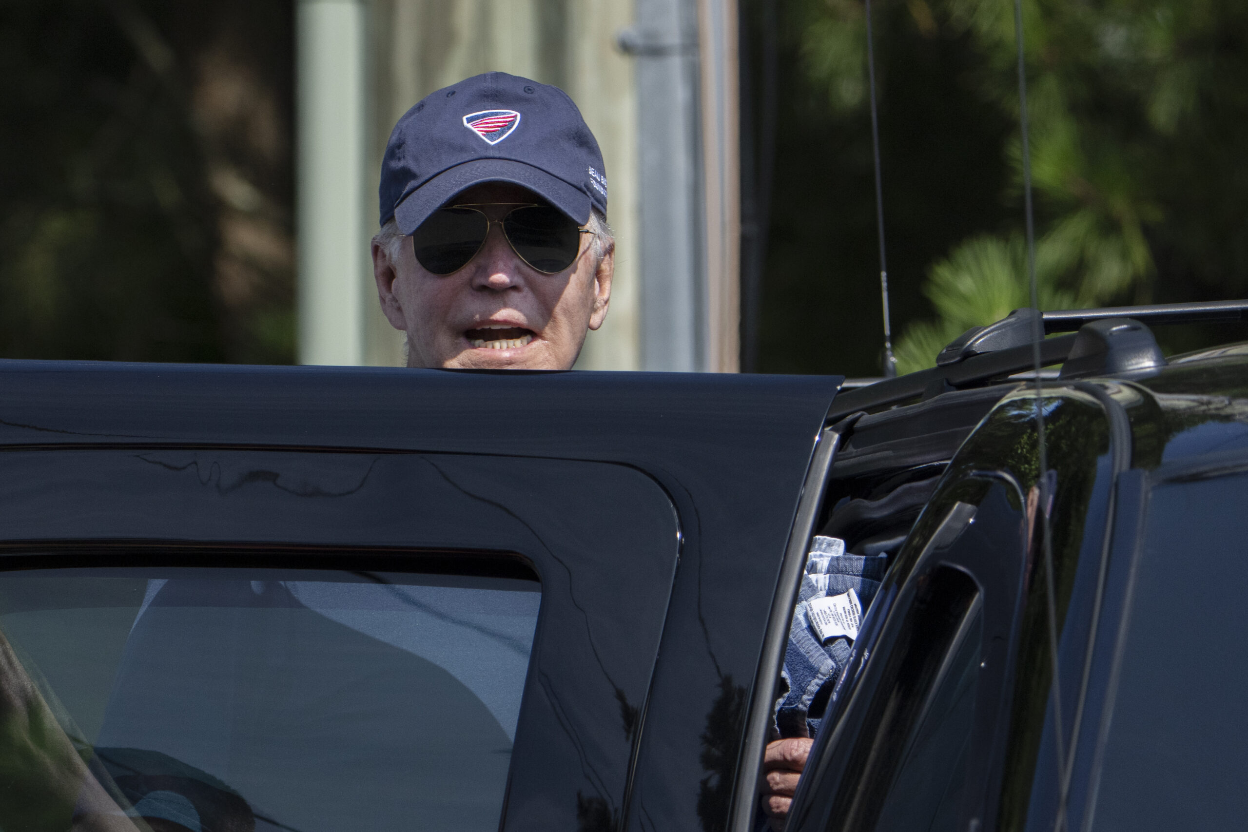 President Joe Biden responds to reporters as he gets in to his presidential vehicle in Rehoboth Bea...