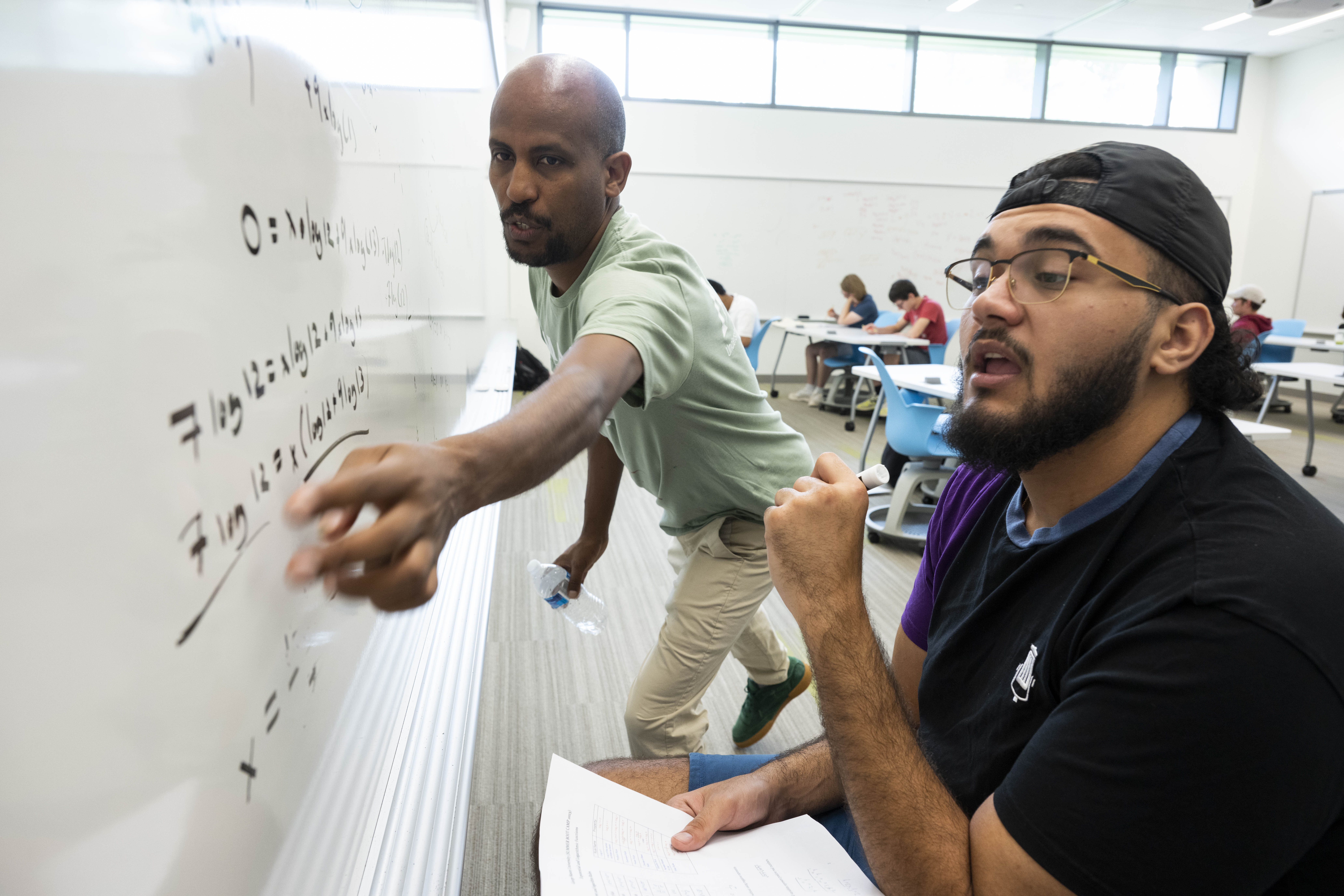 George Mason Term Instructor Ermias Kassaye, left, helps a student figure out an equation during a ...