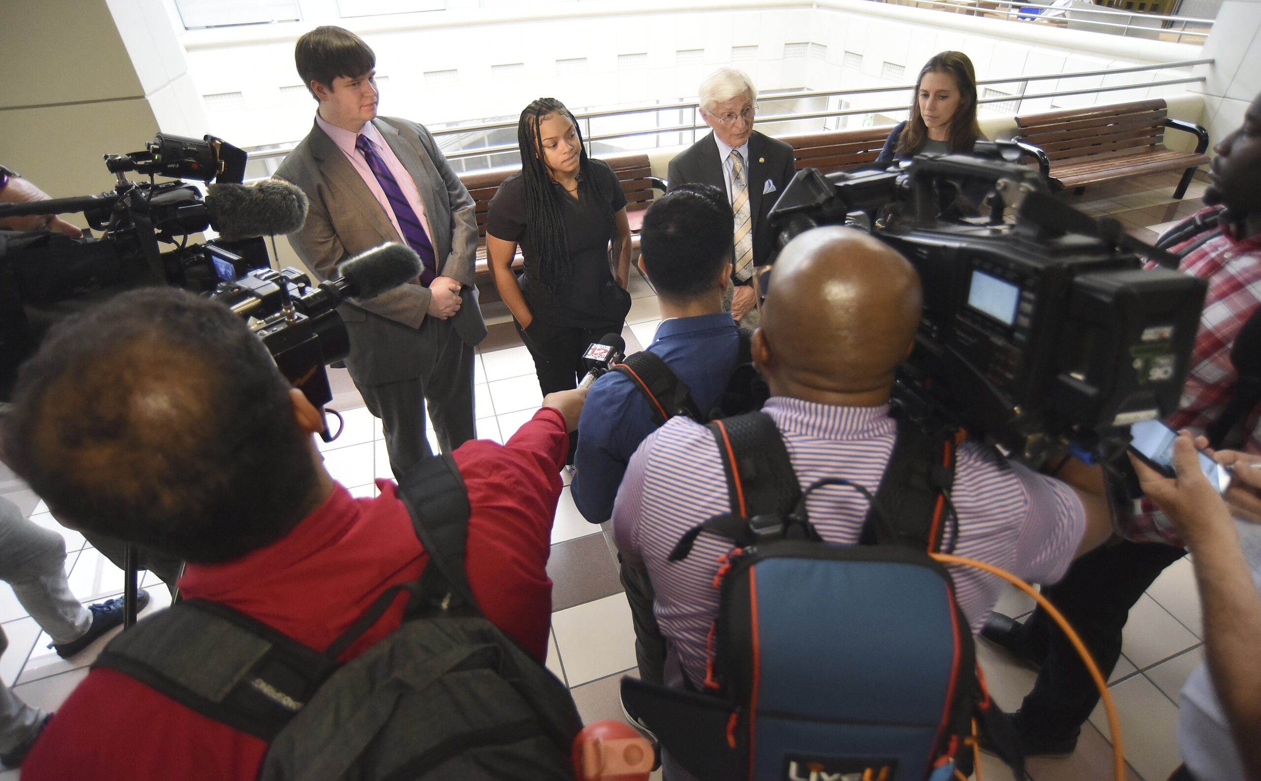 Angel Bumpass talks to members of the media with her lawyers Seth Segraves, left, and William Masse...