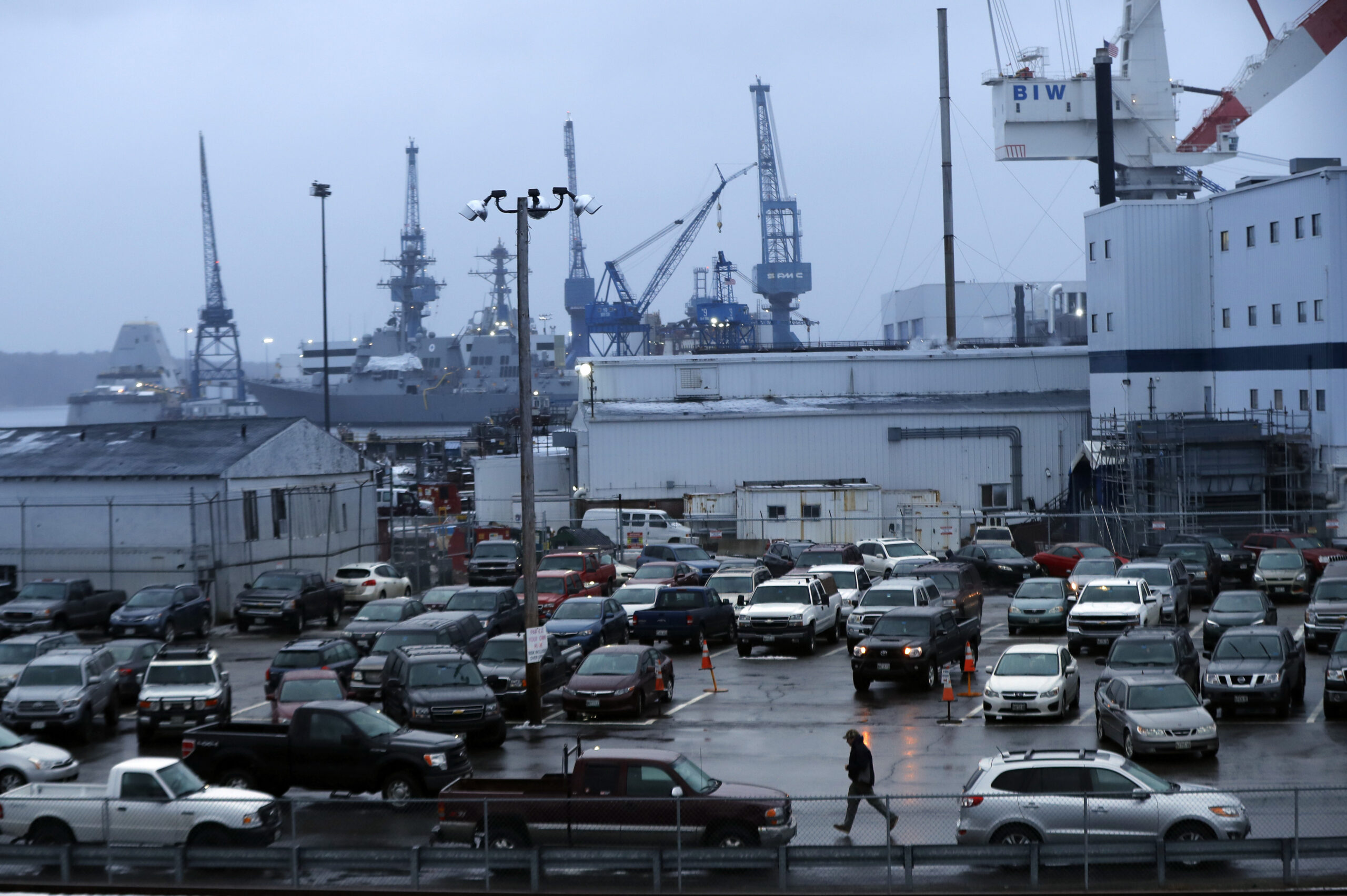 FILE — A shipyard worker, below center, walks to his car at the end of a workday at Bath Iron Wor...