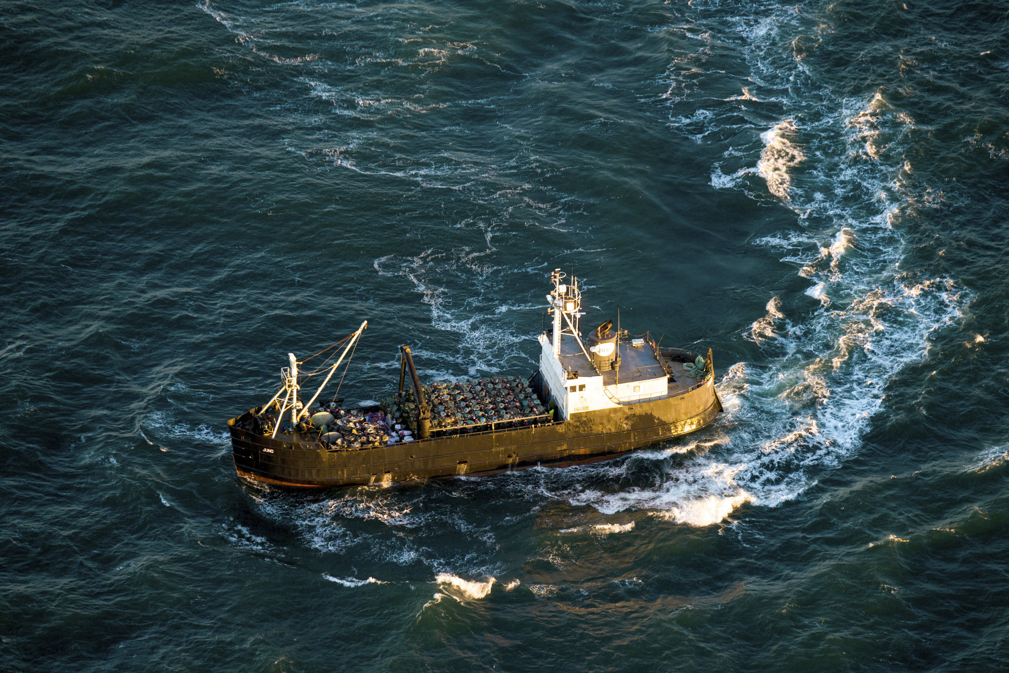 FILE - A crabbing vessel turns below a U.S. Coast Guard flyover inspection of crabbing ships along ...