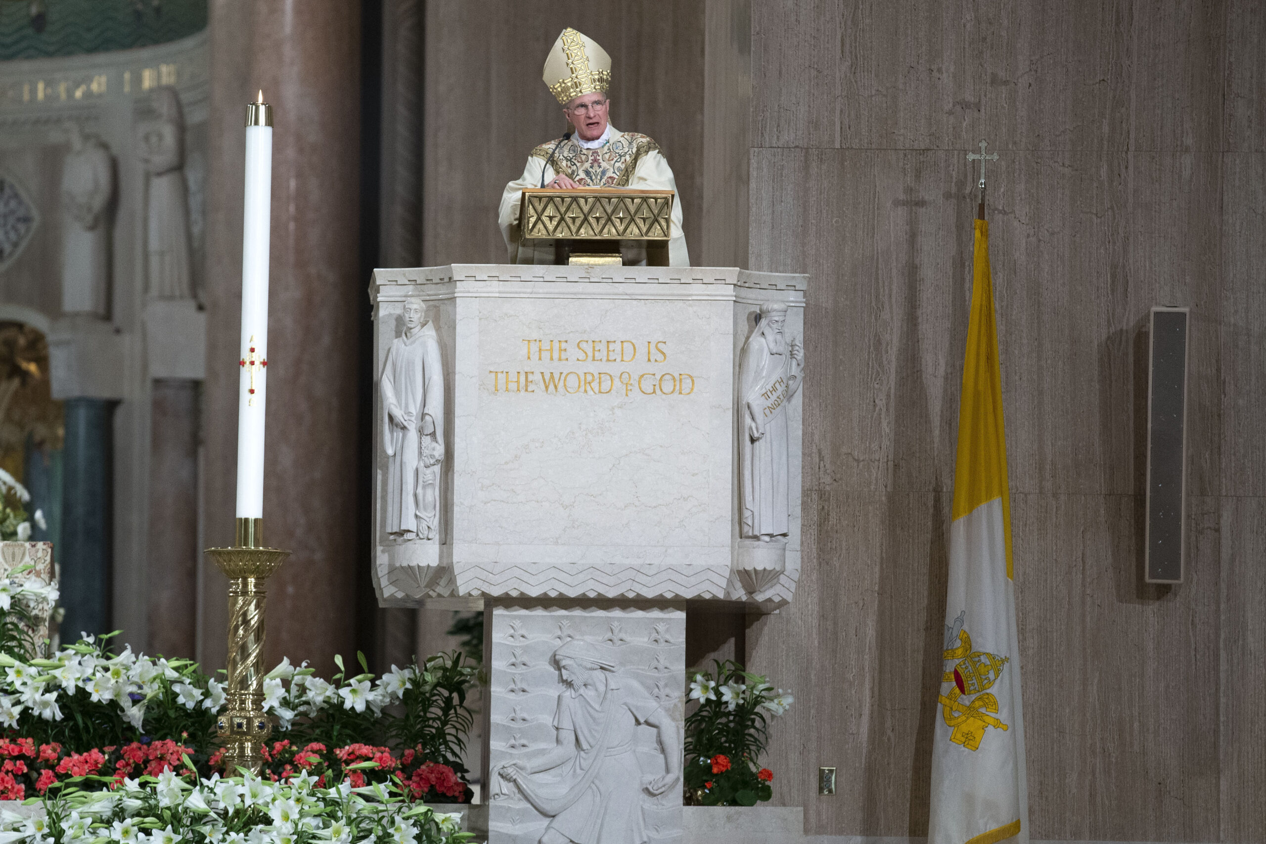 FILE - Archbishop Timothy Broglio conducts an Easter Sunday Mass in an empty sanctuary at Basilica ...