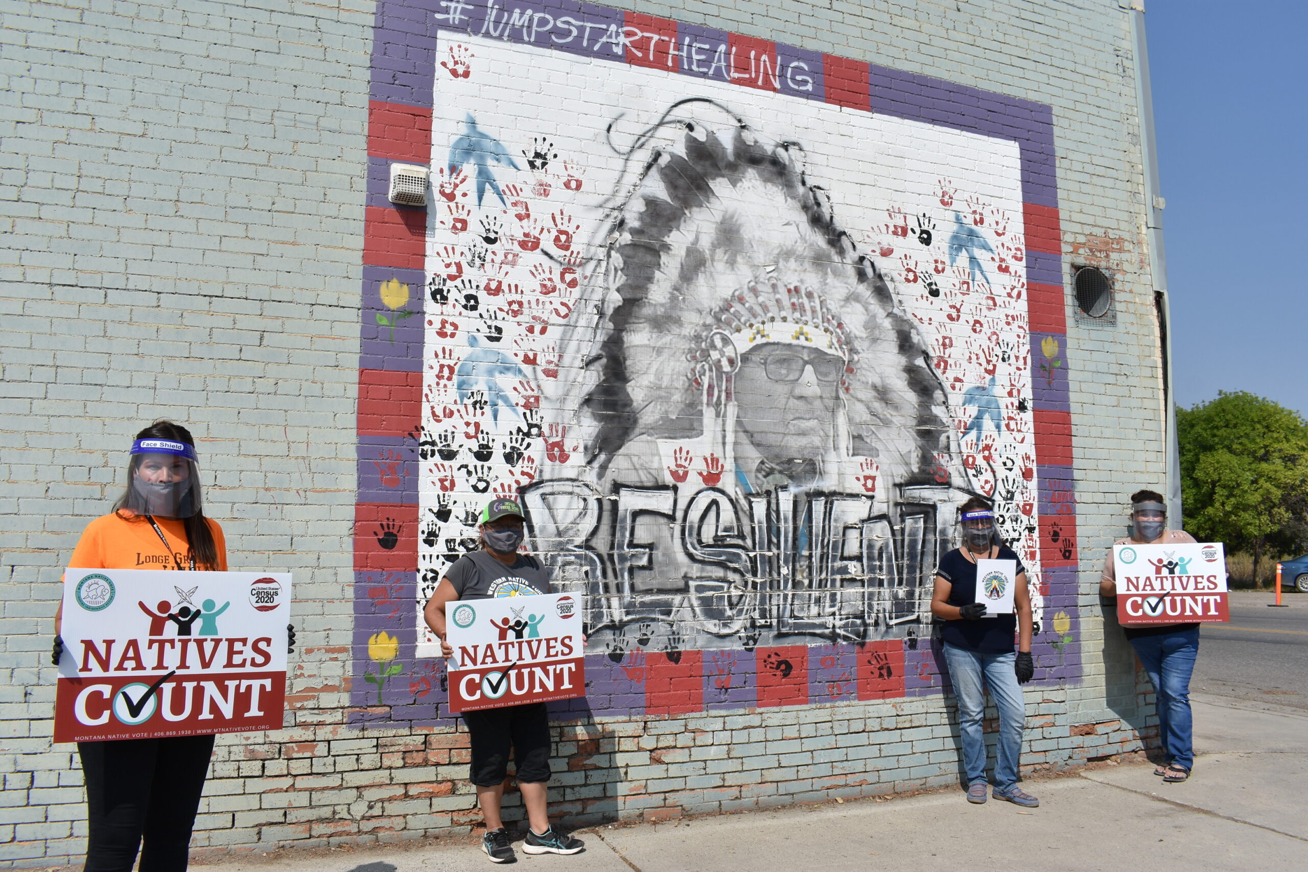 FILE - Activists hold signs promoting Native American participation in the U.S. census in front of ...