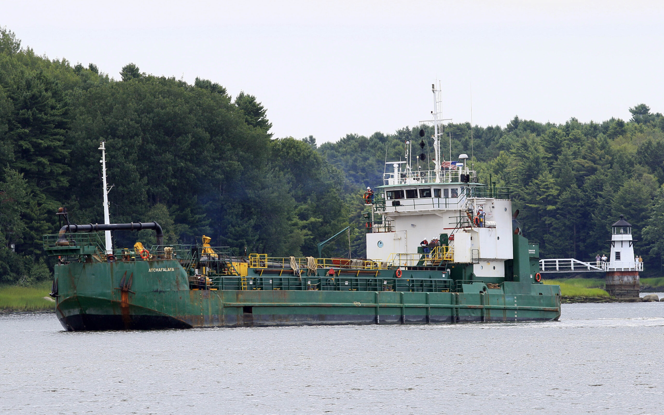 FILE - Spectators watch as a dredger works to deepen a shallow channel in the Kennebec River, upstr...