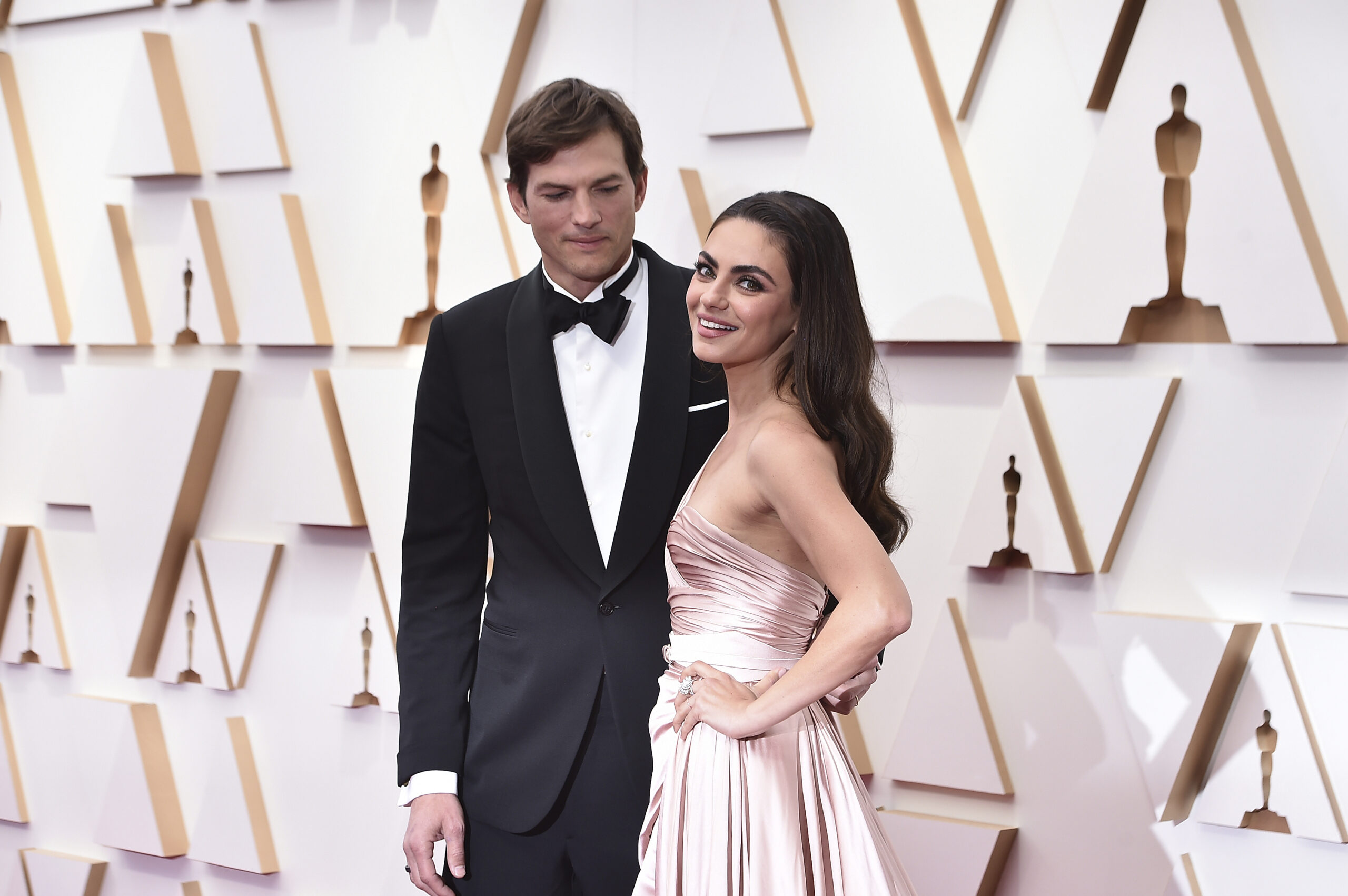 FILE - Ashton Kutcher, left, and Mila Kunis arrive at the Oscars on Sunday, March 27, 2022, at the ...