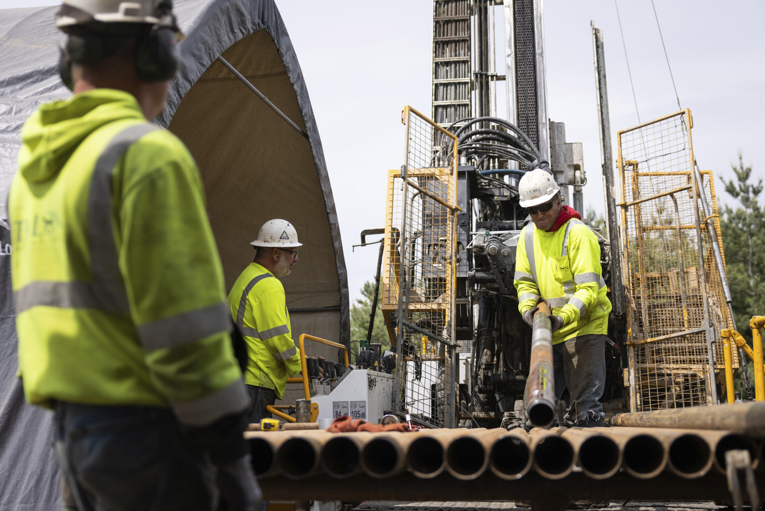 FILE - Driller Helper Chris Palmer, right, attaches a core sampling tube to a drilling rig at the T...