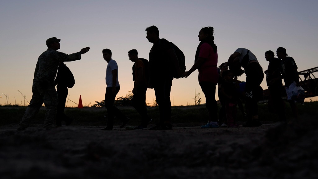 ILE - Migrants who crossed the Rio Grande and entered the U.S. from Mexico are lined up for process...