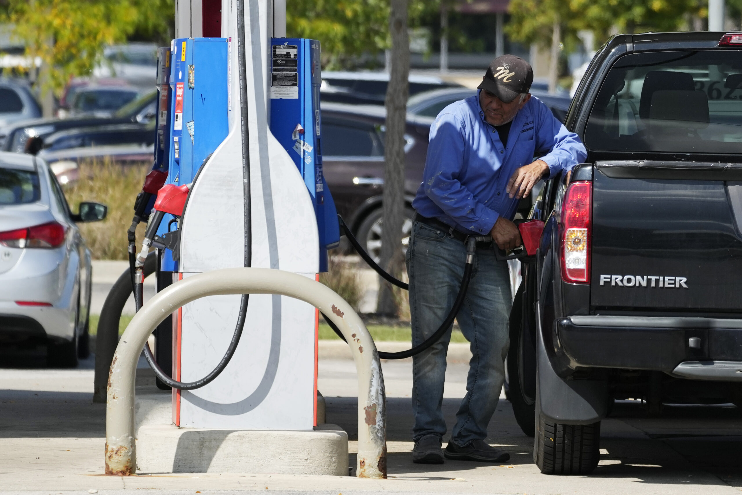 A man fuels his truck at a gas station in Palatine, Ill., Wednesday, Sept. 13, 2023. Higher longer-...