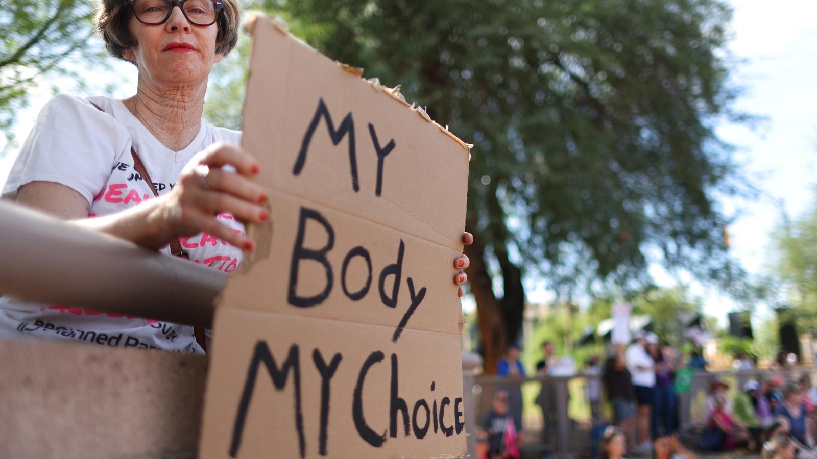 A protestor holds a sign at a Women's March rally outside the Arizona Capitol on Oct. 8, 2022, in P...