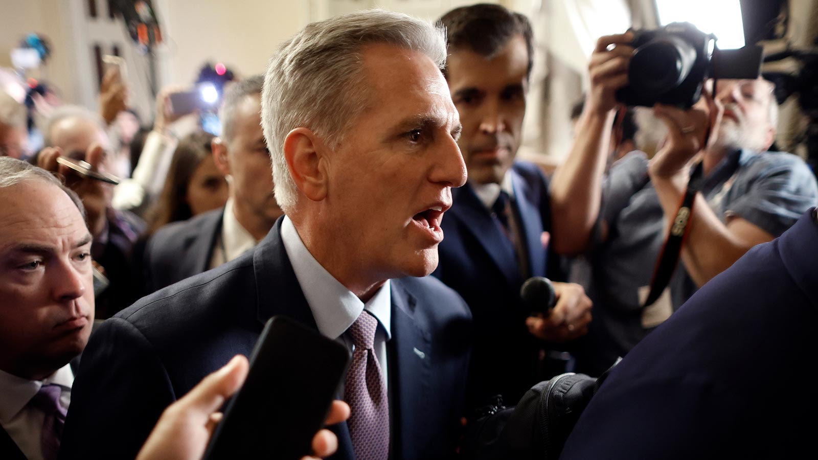 House Speaker Kevin McCarthy is surrounded by staff, security and journalists as he walks to the Ho...