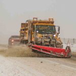 snow being swept up from under a snowplow