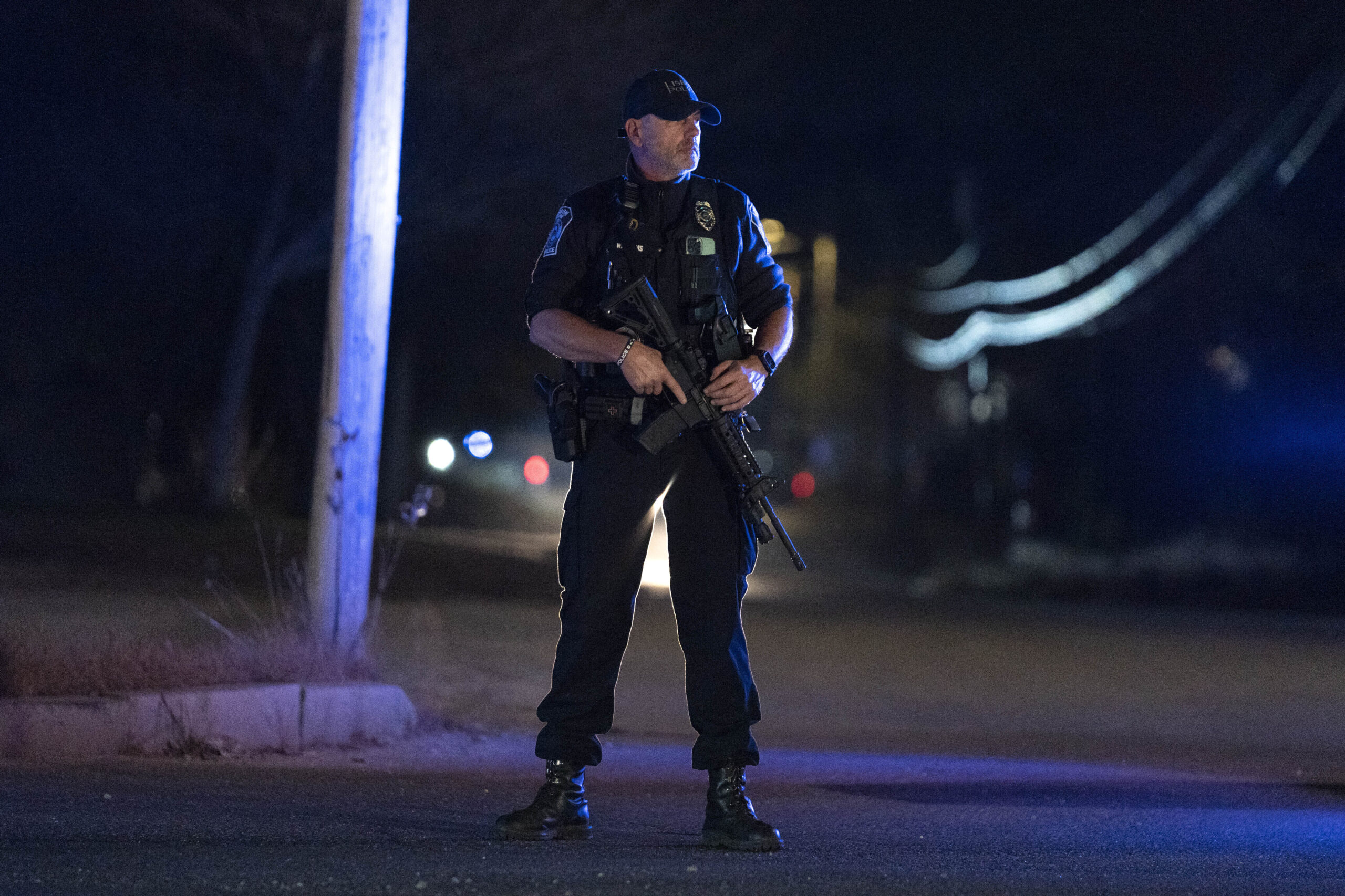 A police officer guards the road where the body of suspected mass shooter Robert Card was found, Fr...
