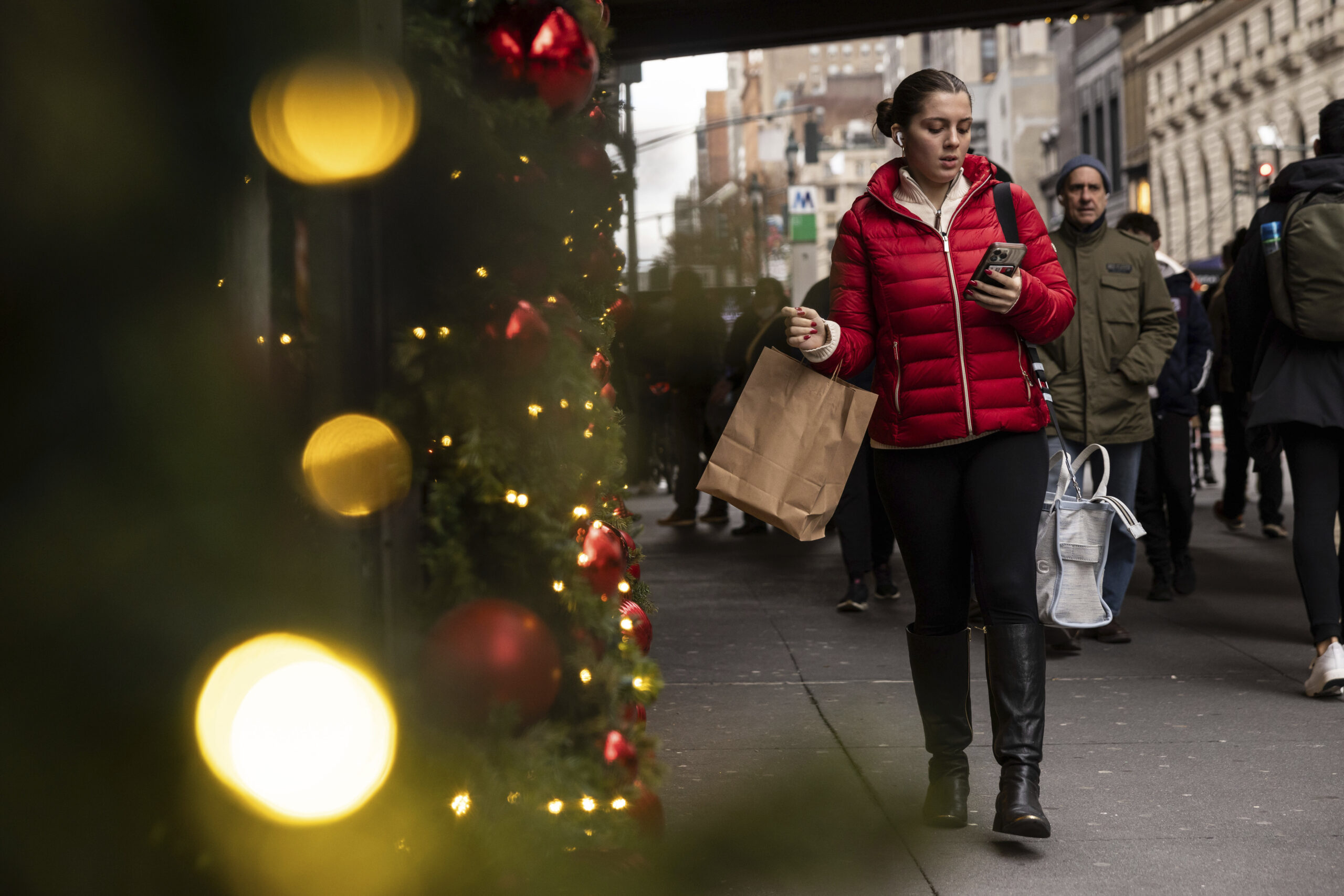 A woman carrying a shopping bag passes Macy's department store in Herald Square, Monday, Dec. 11, 2...