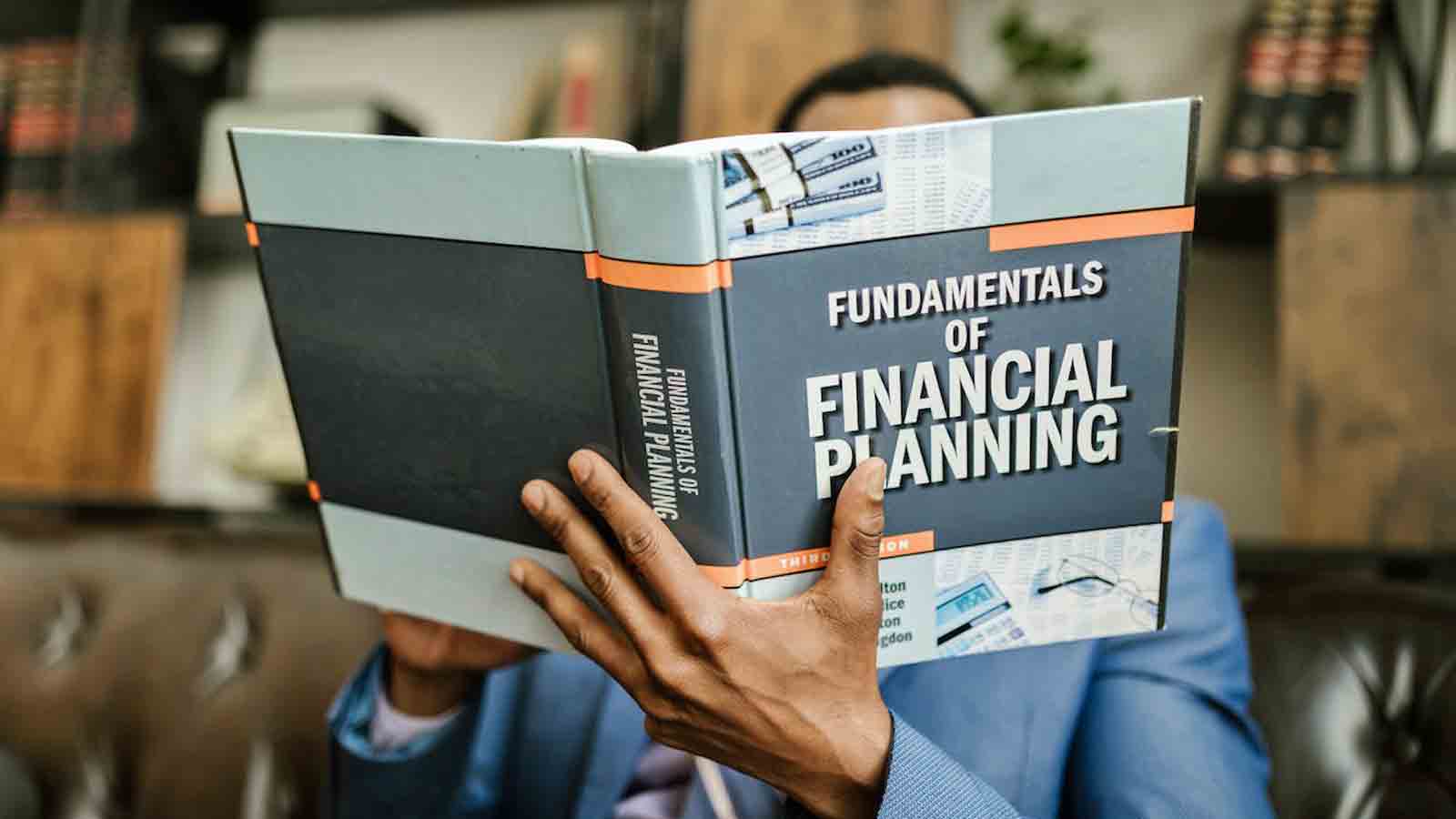 Person reading book about financial planning....