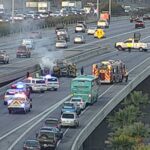 A vehicle smolders after catching fire on a Phoenix freeway ramp