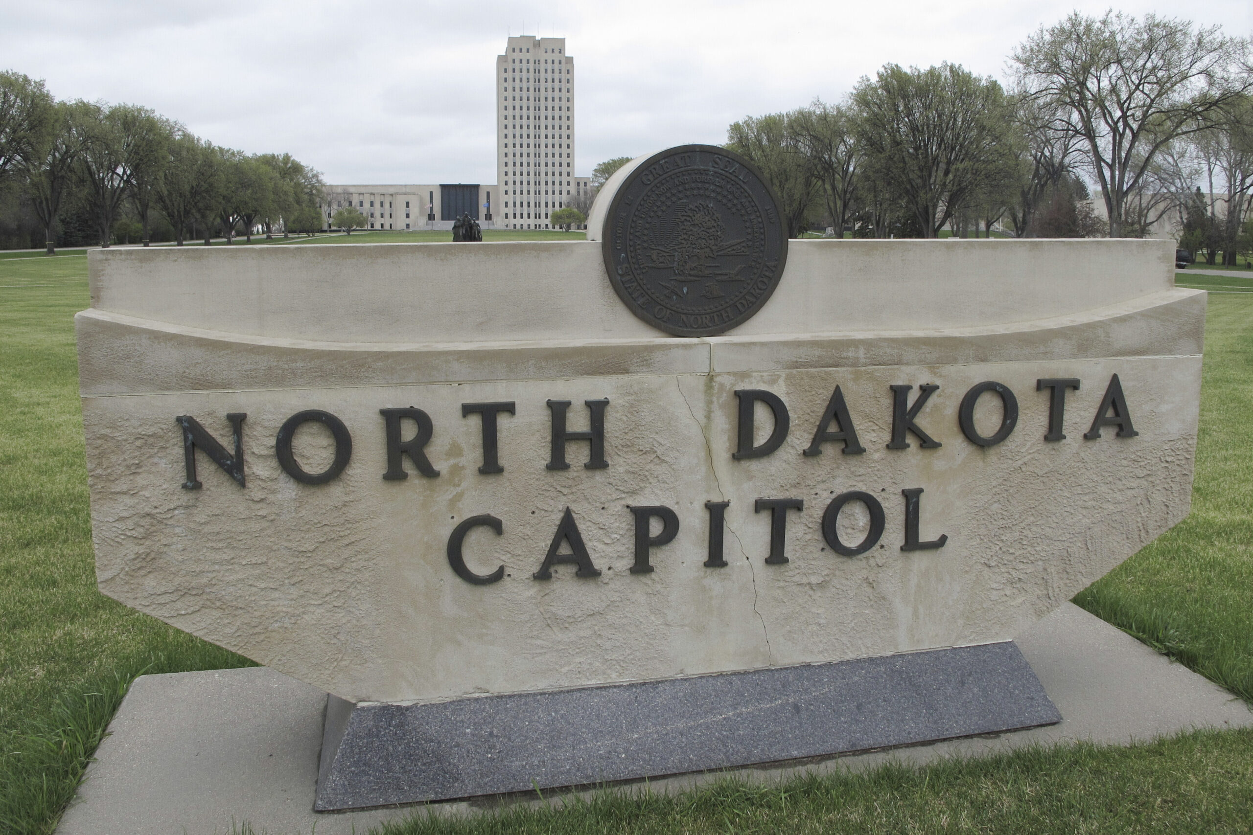 FILE - The North Dakota Capitol tower rises in the background behind a stone sign, April 19, 2012, ...