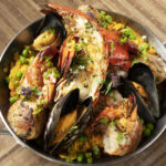 Paella featuring lobster tail, jumbo prawns, diver scallops, mussels, chorizo, arborio rice, English peas, onions, peppers and sherry saffron broth. (The Westin Kierland Resort & Spa)