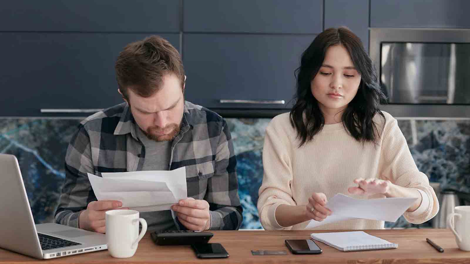 Couple sits at table, seemingly planning out life....