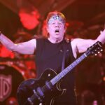 George Thorogood holds his arms out while wearing a guitar  onstage. Thorogood and his band, the Destroyers, will perform at Arizona Bike Week 2024.