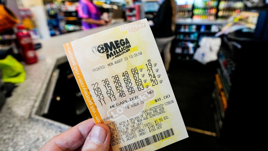 A Mega Millions ticket is seen as a person makes a purchase inside a convenience store, Aug. 7, 202...