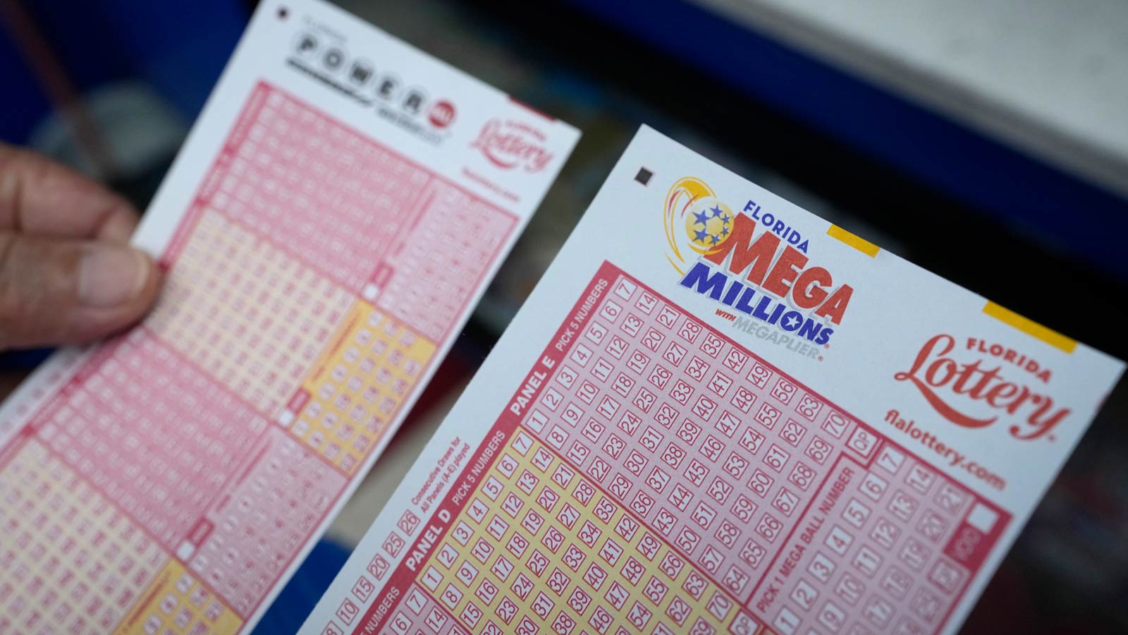 A lottery player holds forms to pick numbers for the Powerball and Mega Millions games as he buys t...