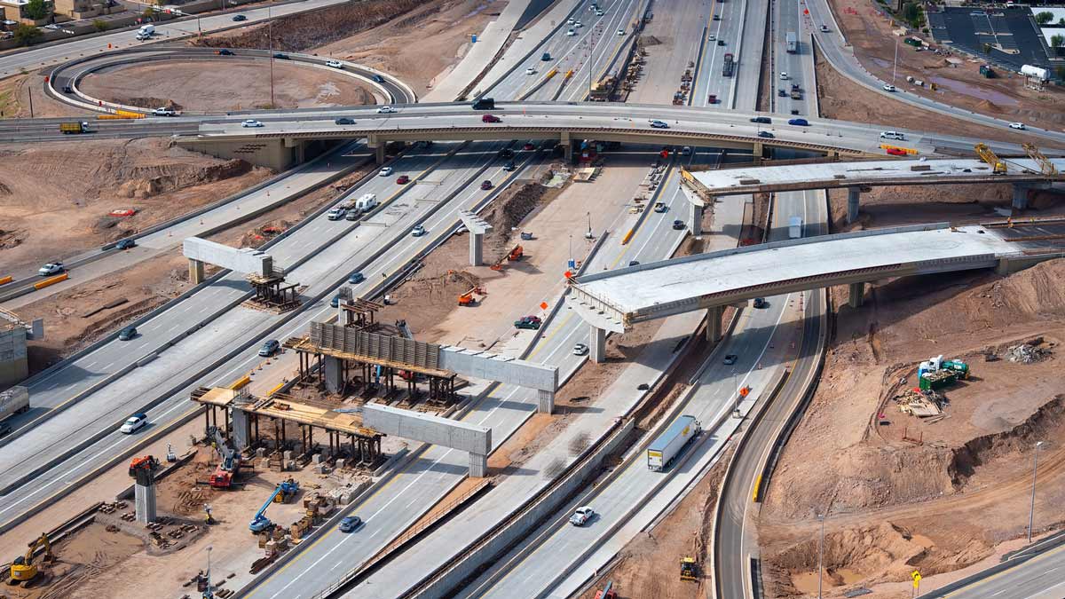 An overhead photo shows crews working on new bridges over Interstate 10 at the State Route 143 inte...