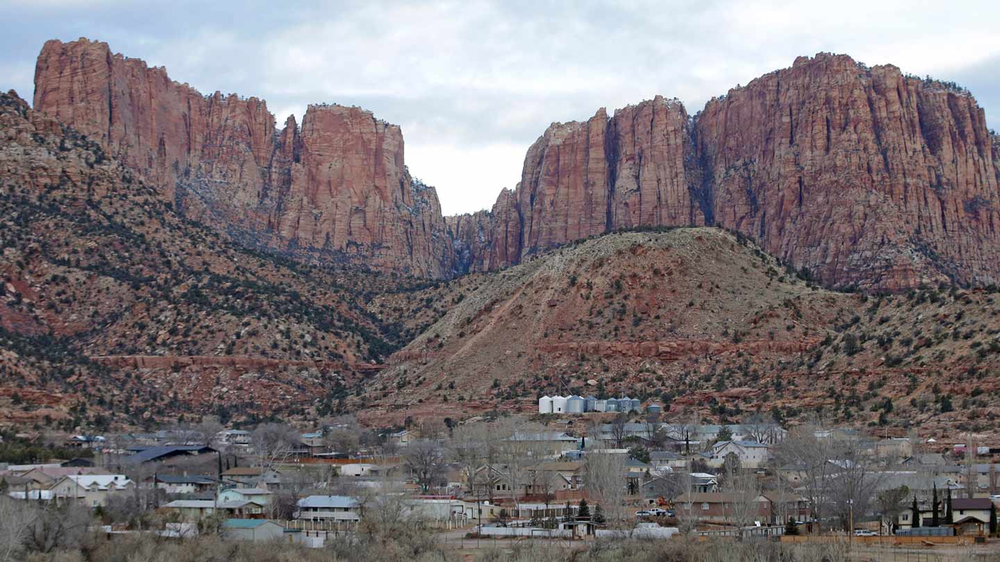 Hildale, Utah, is pictured sitting at the base of Red Rock Cliff mountains, with its sister city, C...