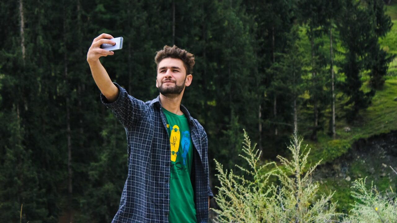 Man taking a selfie in a grassy area....