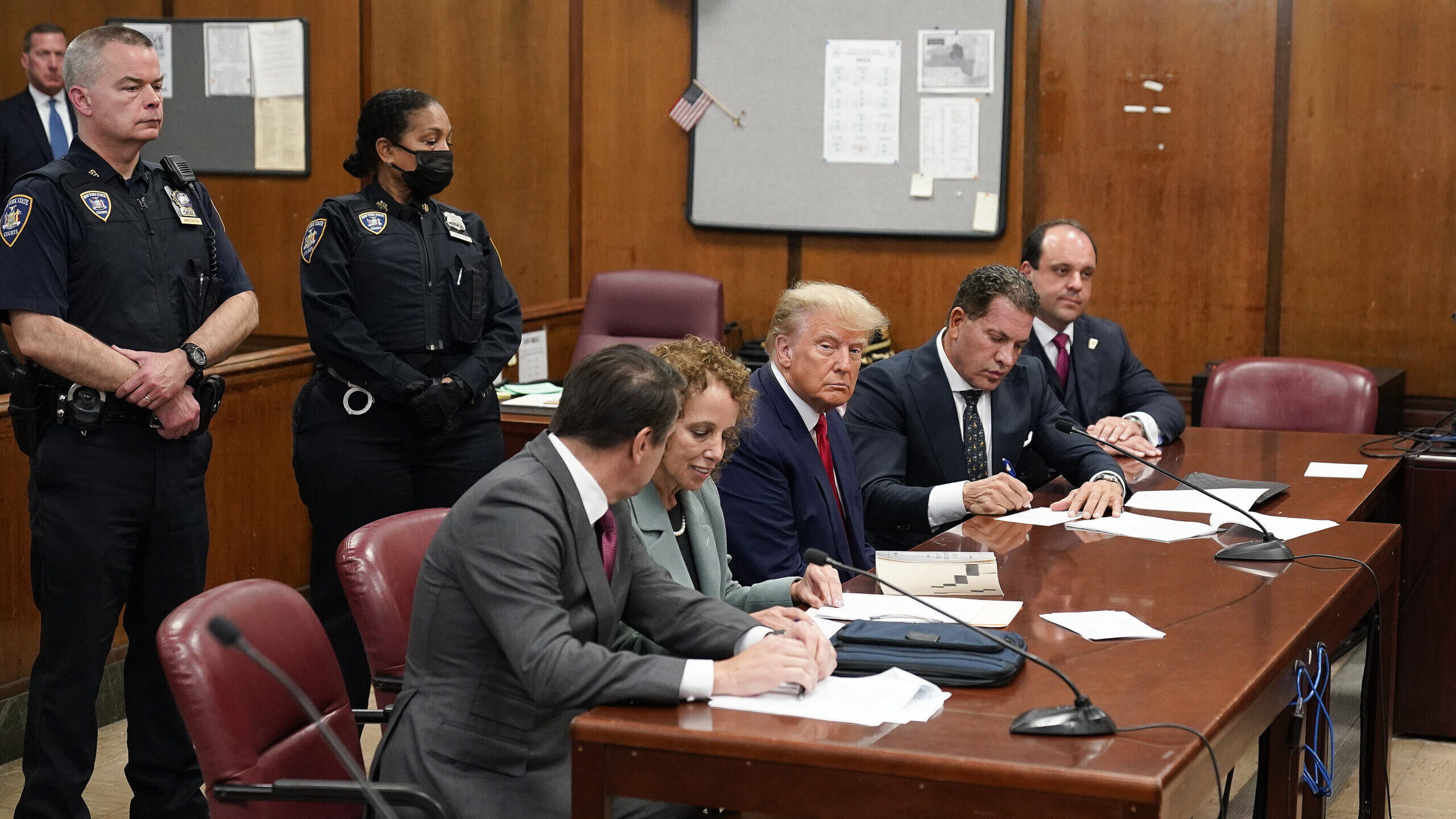 Former President Donald Trump, center, appears in court for his arraignment, Tuesday, April 4, 2023...