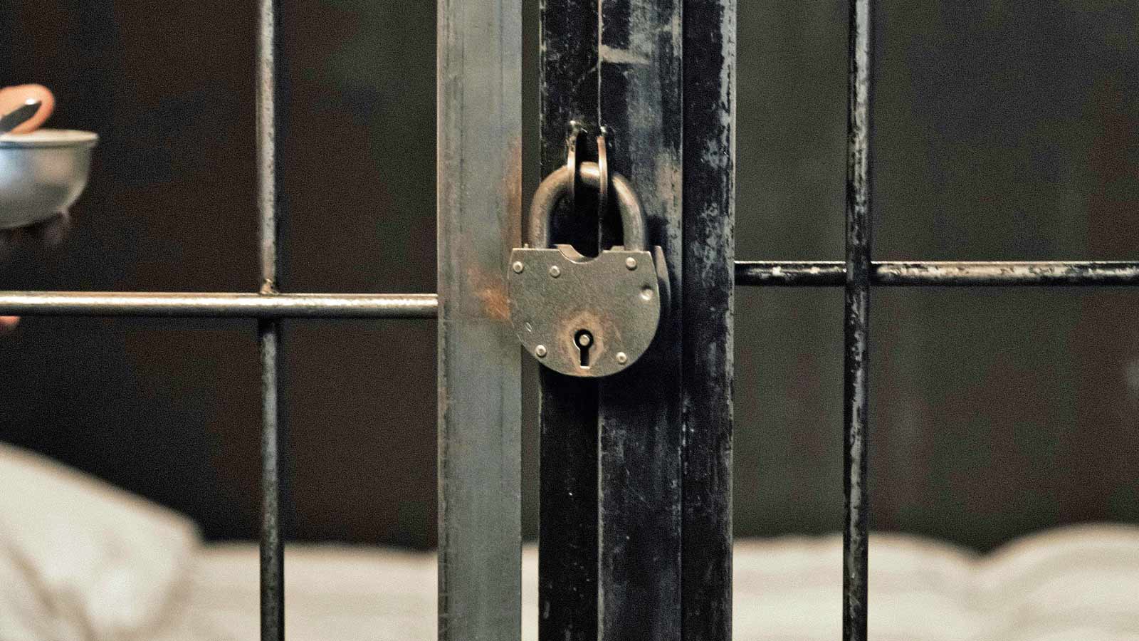 Stock image of a padlock on prison bars. A woman was sentenced to 3.5 years in prison for her role ...