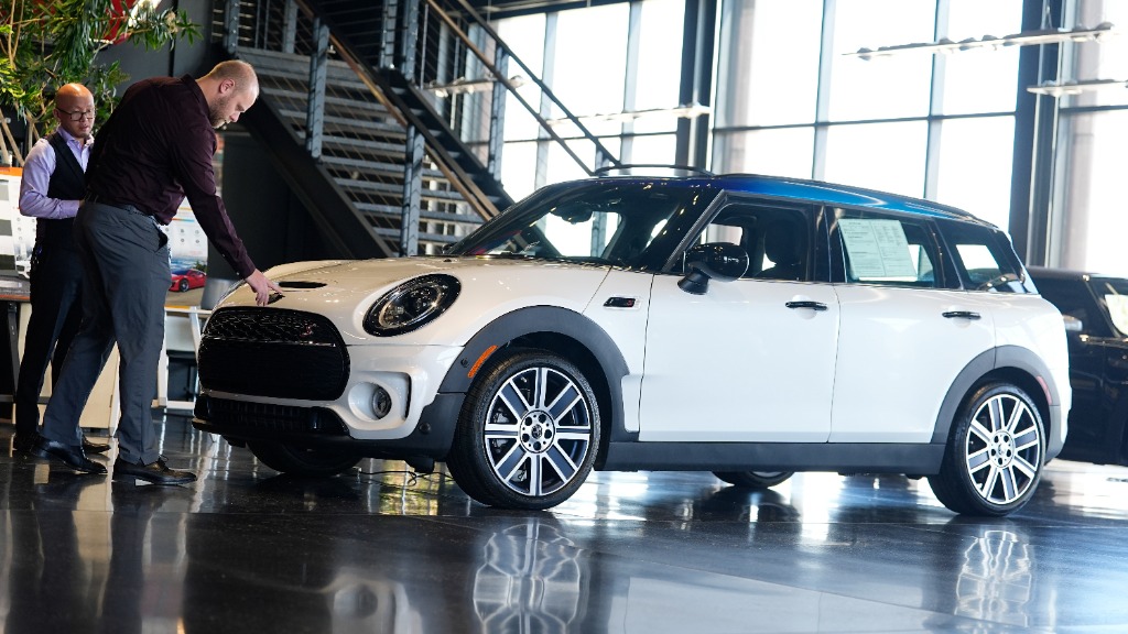 FILE - Salesmen examine an unsold 2024 Cooper Clubman S utility vehicle at a Mini dealership May 1,...