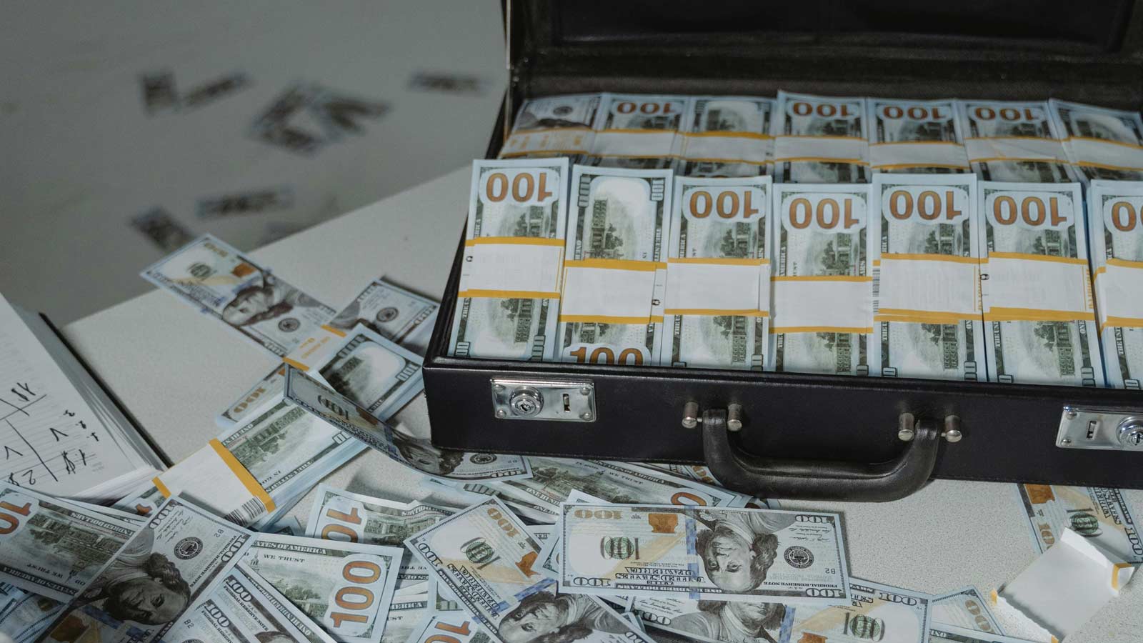 Stock image of a briefcase overflowing with hundred-dollar bills. Metro Phoenix lottery players won...