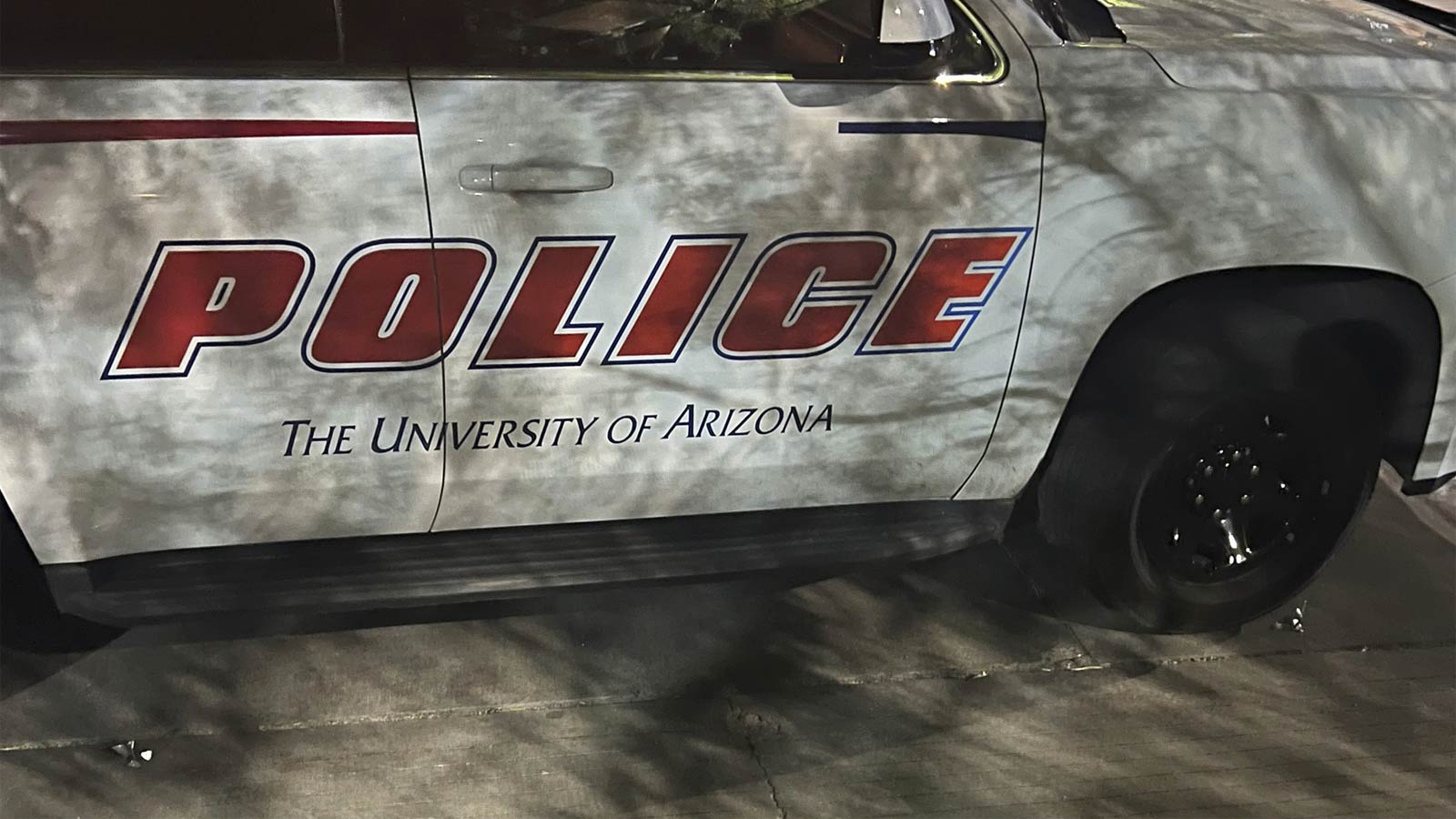 Spikes can be seen on the ground next to the front and back tires of a University of Arizona police...