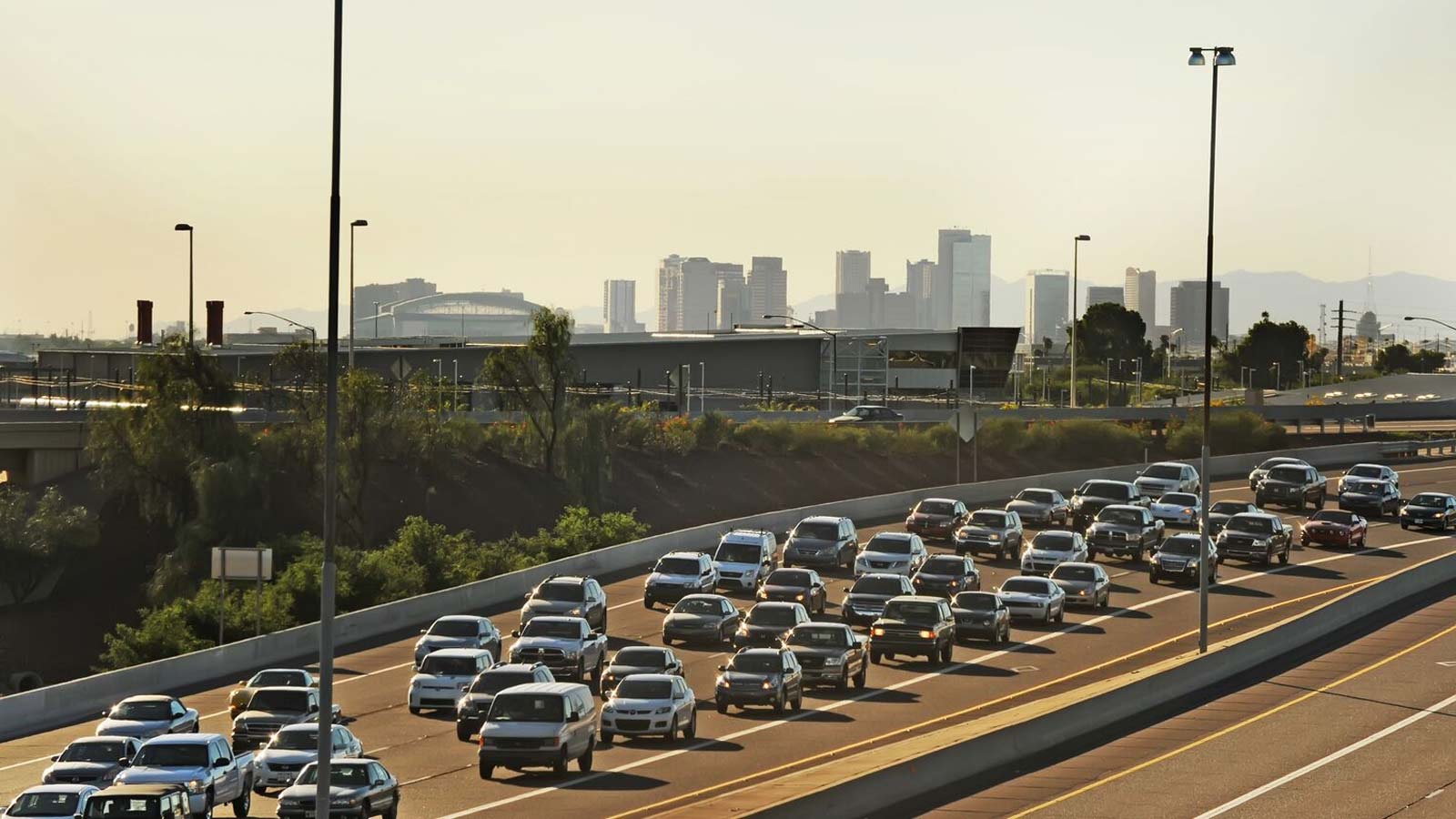 Vehicles fill a Phoenix freeway with the city skyline in the background. A ballot measure to extend...