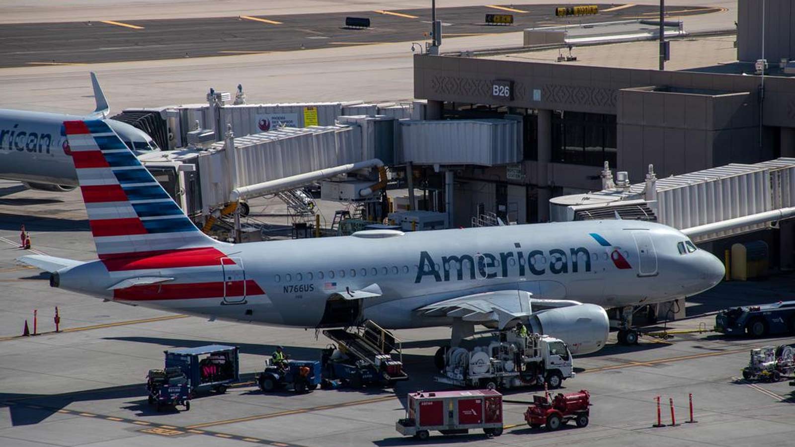 An American Airlines jet sits at a Phoenix Sky Harbor International Airport gate in a file photo....
