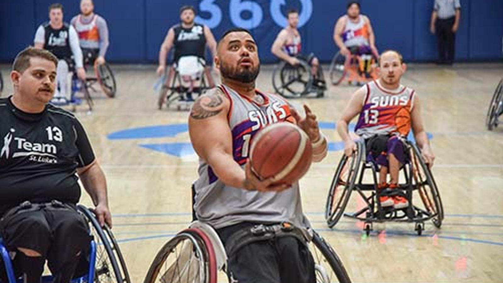 A Wheelchair Suns player holds a basketball during a game. The team encountered problems while trav...