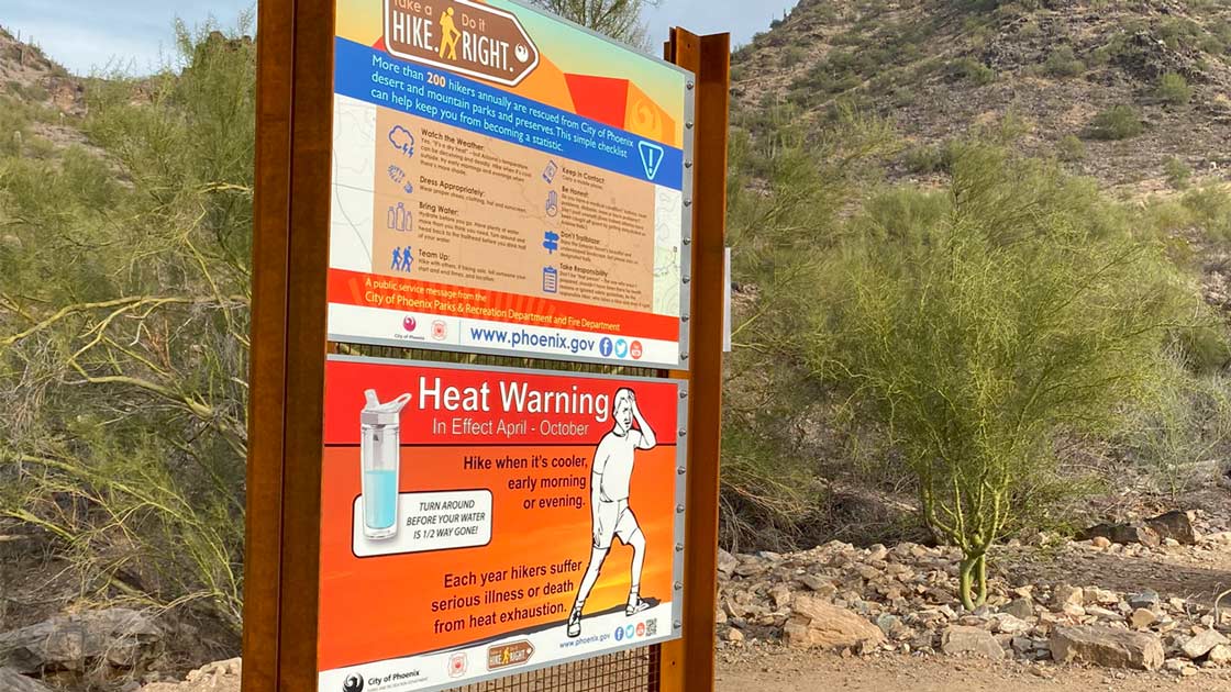 A sign about safe hiking is seen at the Piestewa Peak hiking area in Phoenix. Phoenix is under an e...
