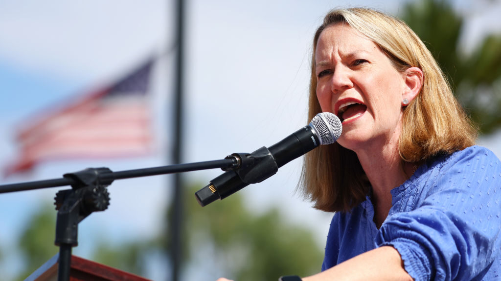 Arizona Attorney General Kris Mayes gives speech at podium...