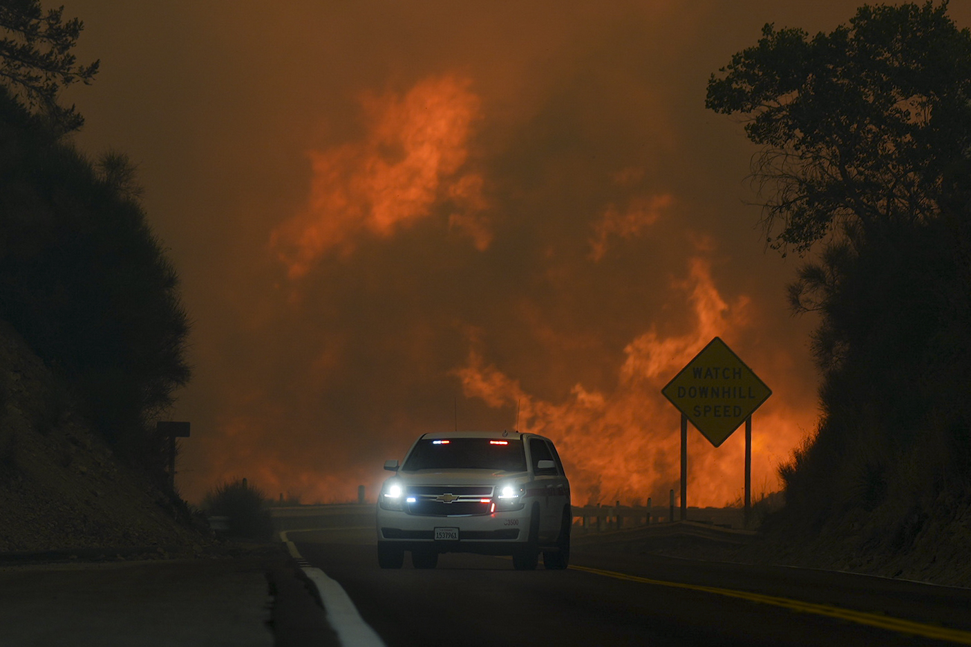 The Line Fire jumps highway 330 as an emergency vehicle is driven past Saturday, Sept. 7, 2024, nea...