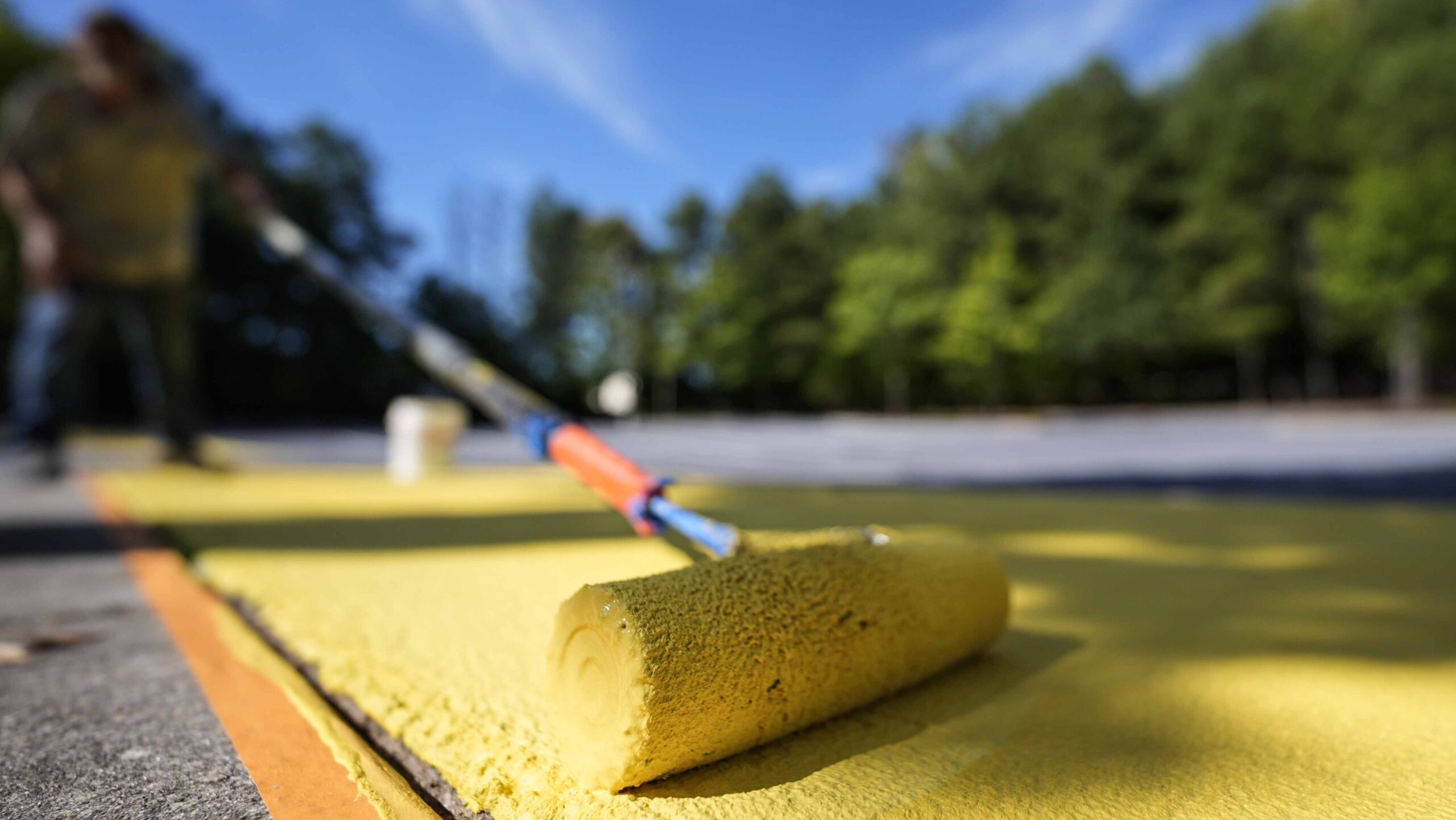 Ronnie Jefferies paints the parking lot at Science, Arts and Entrepreneurship School to help cool i...